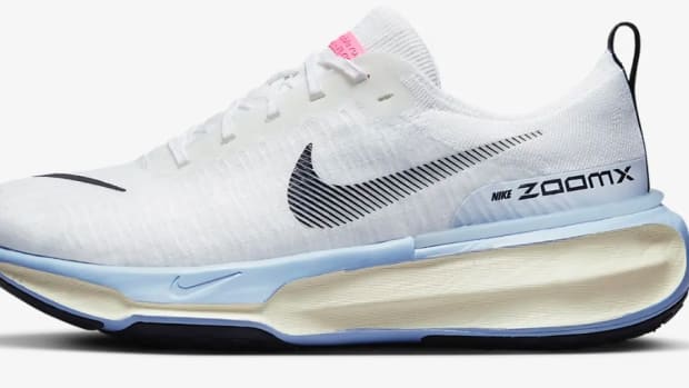 Side view of white and blue Nike shoe.